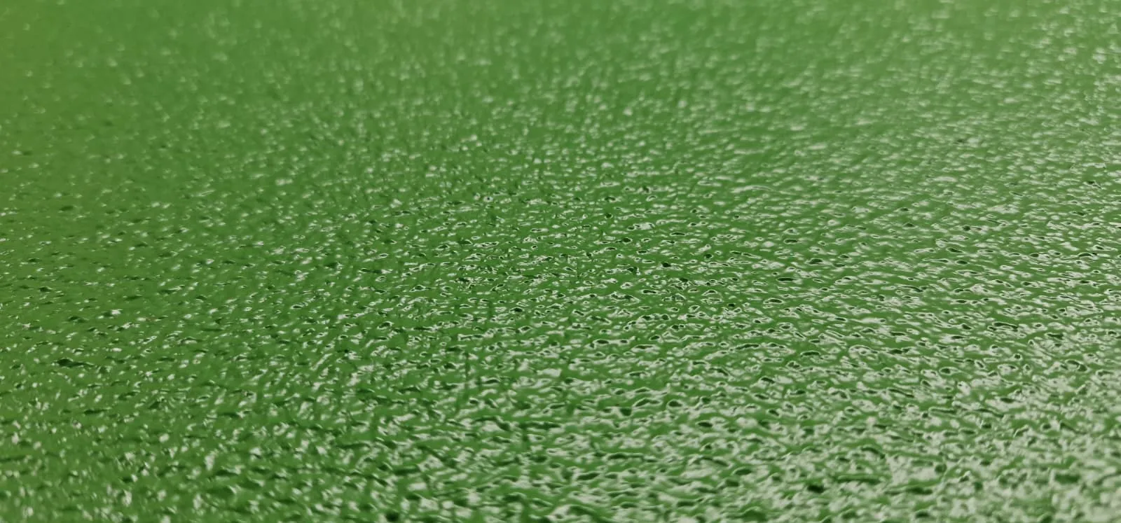 Close-up of tough green textured two-part polyurethane coating on a speaker cabinet